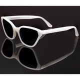 This handmade designer cat eye shaped eyewear is made using premium italian white pearlescent high gloss acetate. The lenses have olive green solid tint. The eyewear is photographed on a black surface.